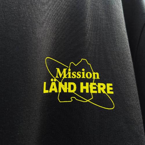 Schwarzes T-Shirt mit Mission LÄND HERE Aufdruck